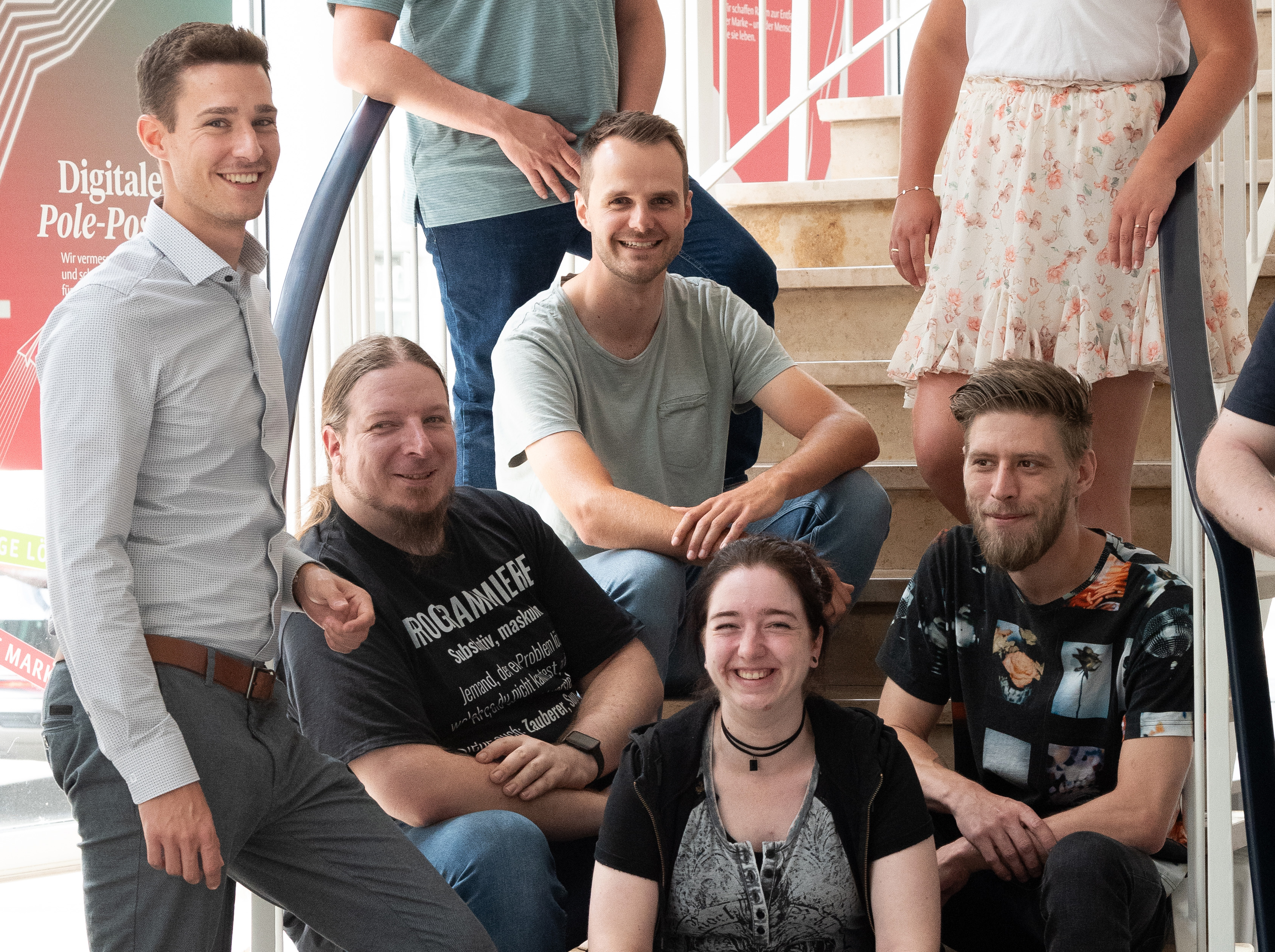 Glückliches Team Gruppe von Menschen auf Treppe angeordnet lachen fröhlich in die Kamera